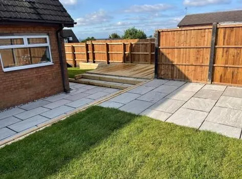 a backyard with a wooden fence and grass