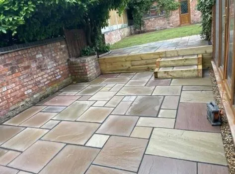 a patio with a brick wall and steps