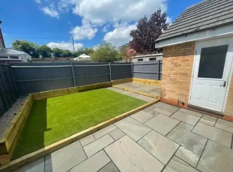 a small backyard with a green lawn and a white door
