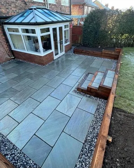 a backyard with a patio and steps leading up to it