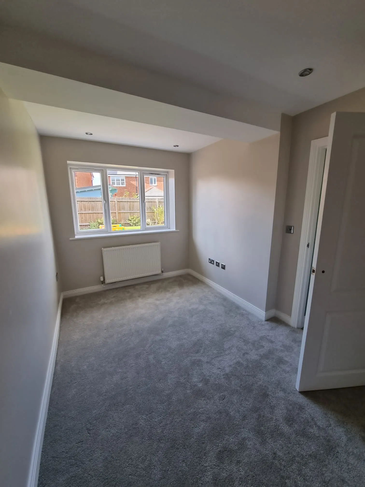 an empty room with a window and a radiator