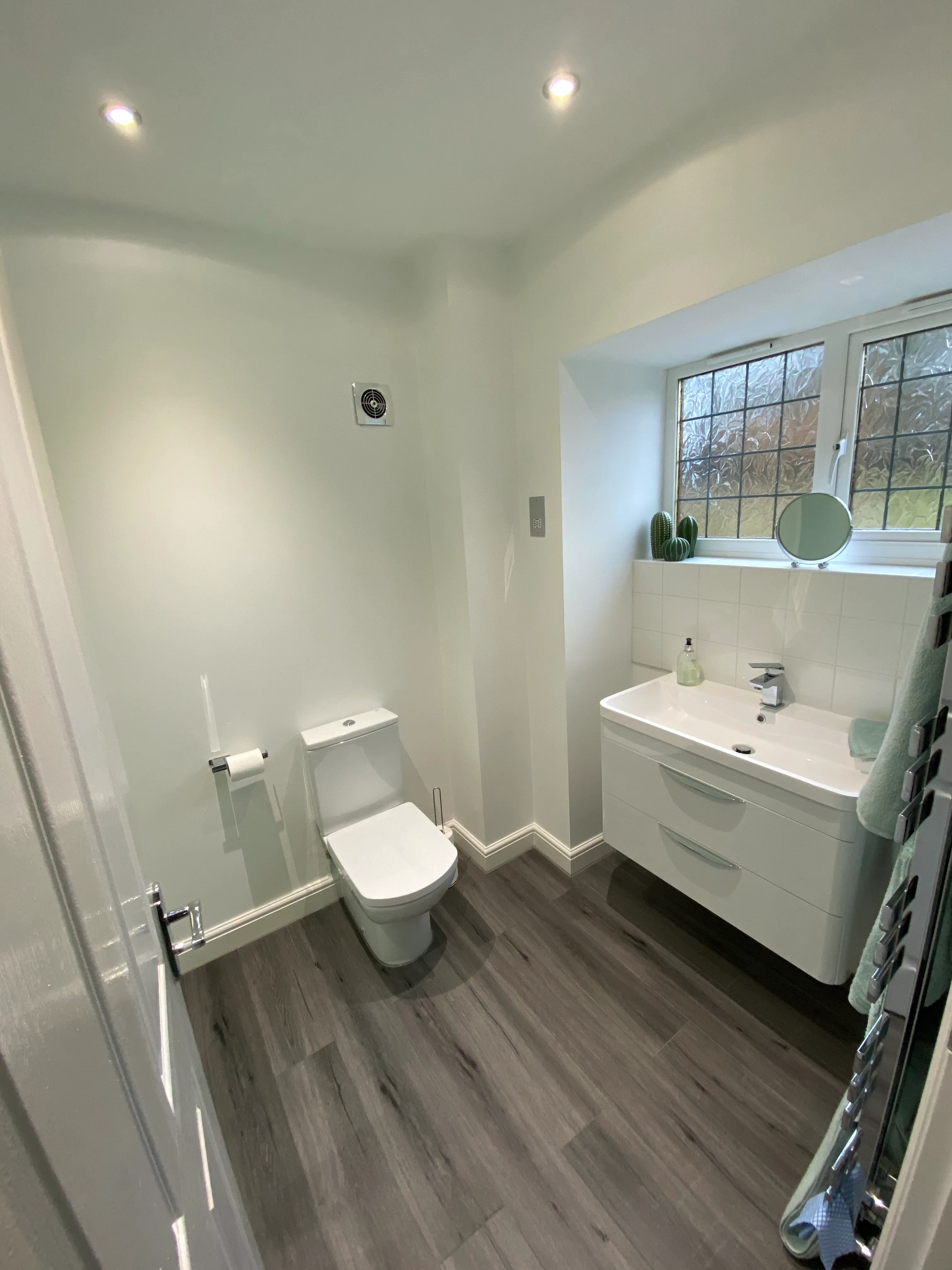 a bathroom with a toilet, sink, and mirror