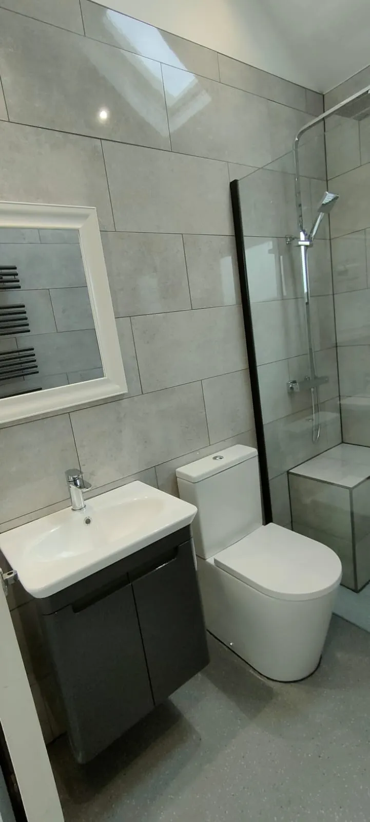 a white toilet sitting next to a walk in shower