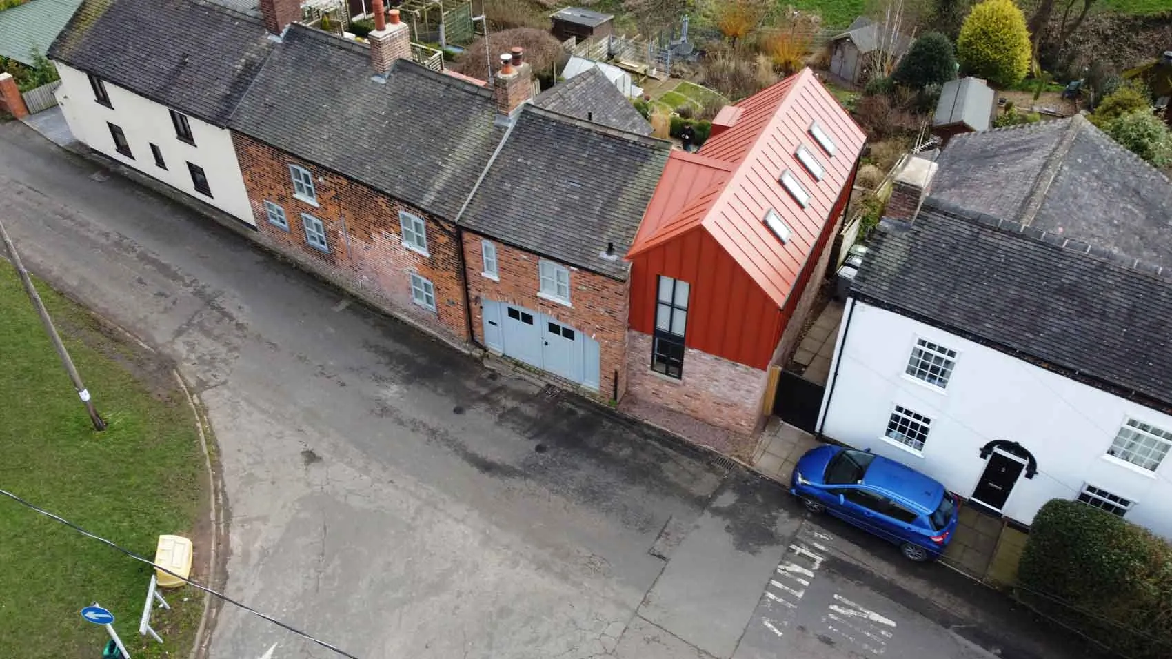 a blue car parked in front of a red brick building