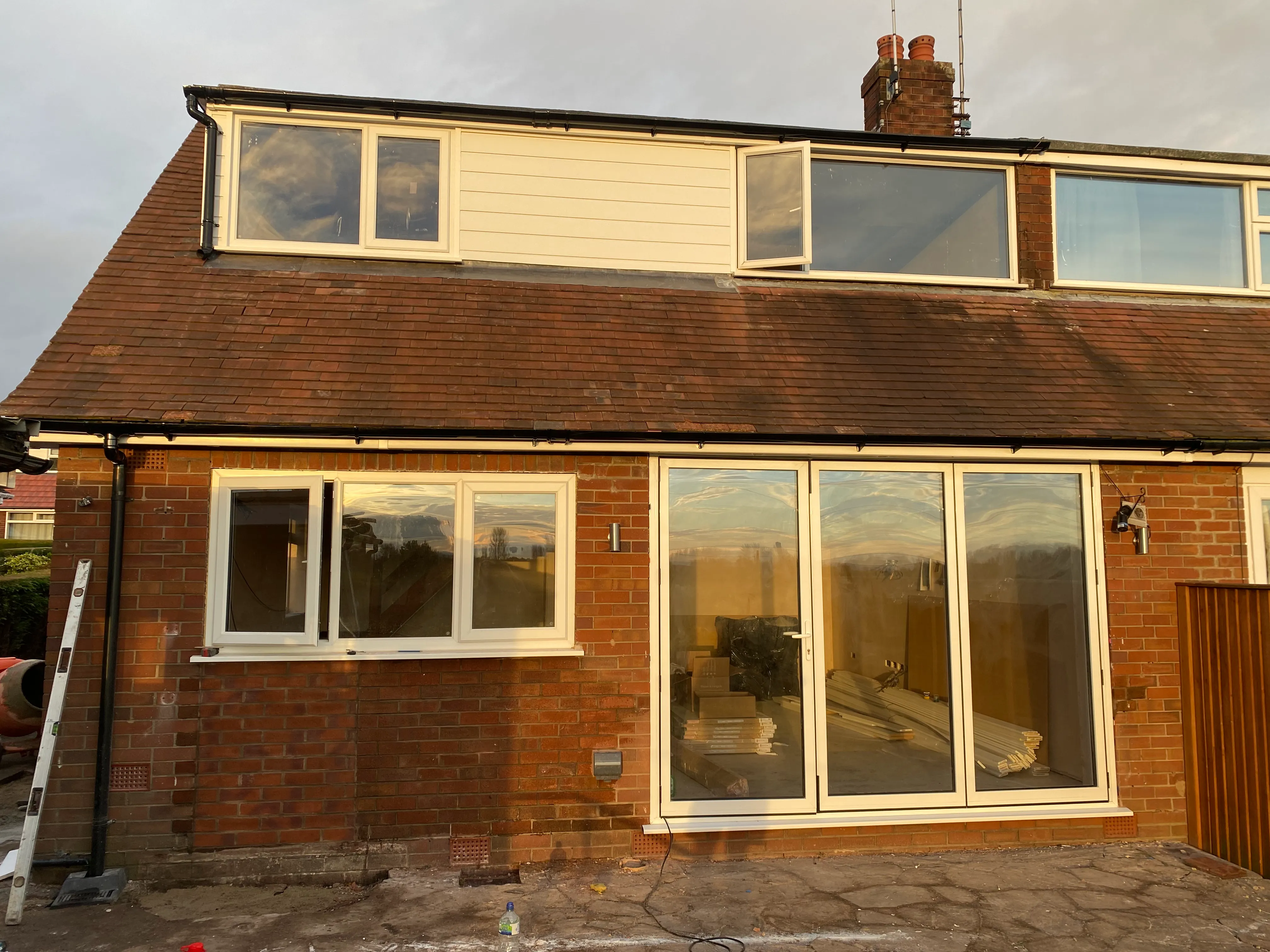 a brick house with a brown roof and white windows