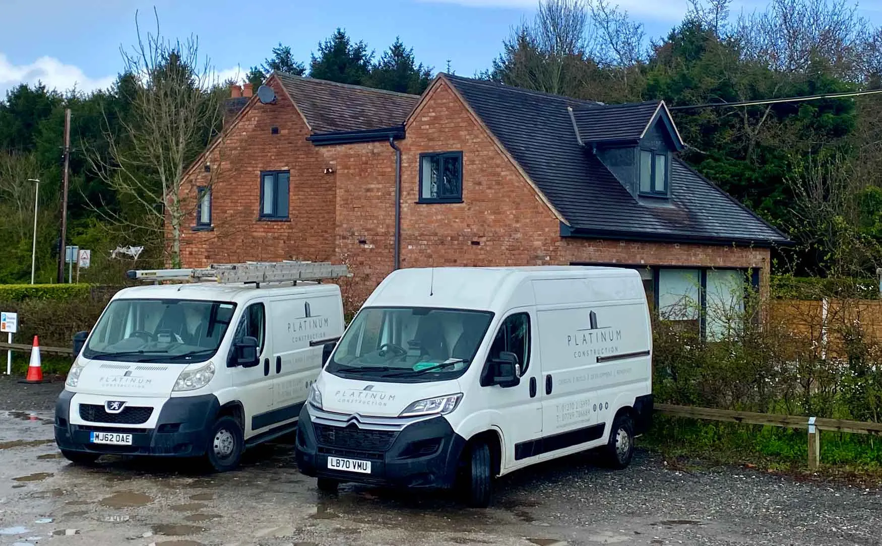 two white vans parked in front of a house