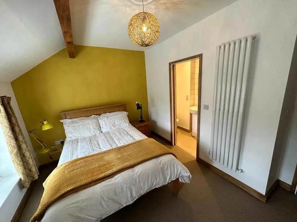 a bed room with a neatly made bed and a radiator
