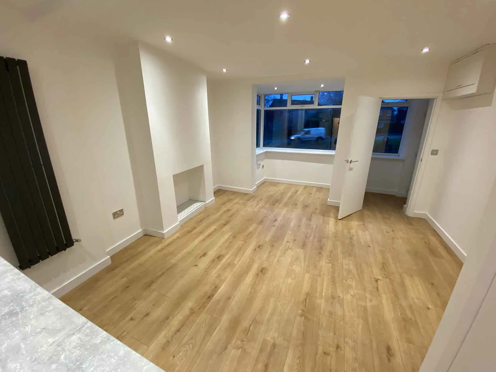 an empty room with hard wood flooring and a radiator