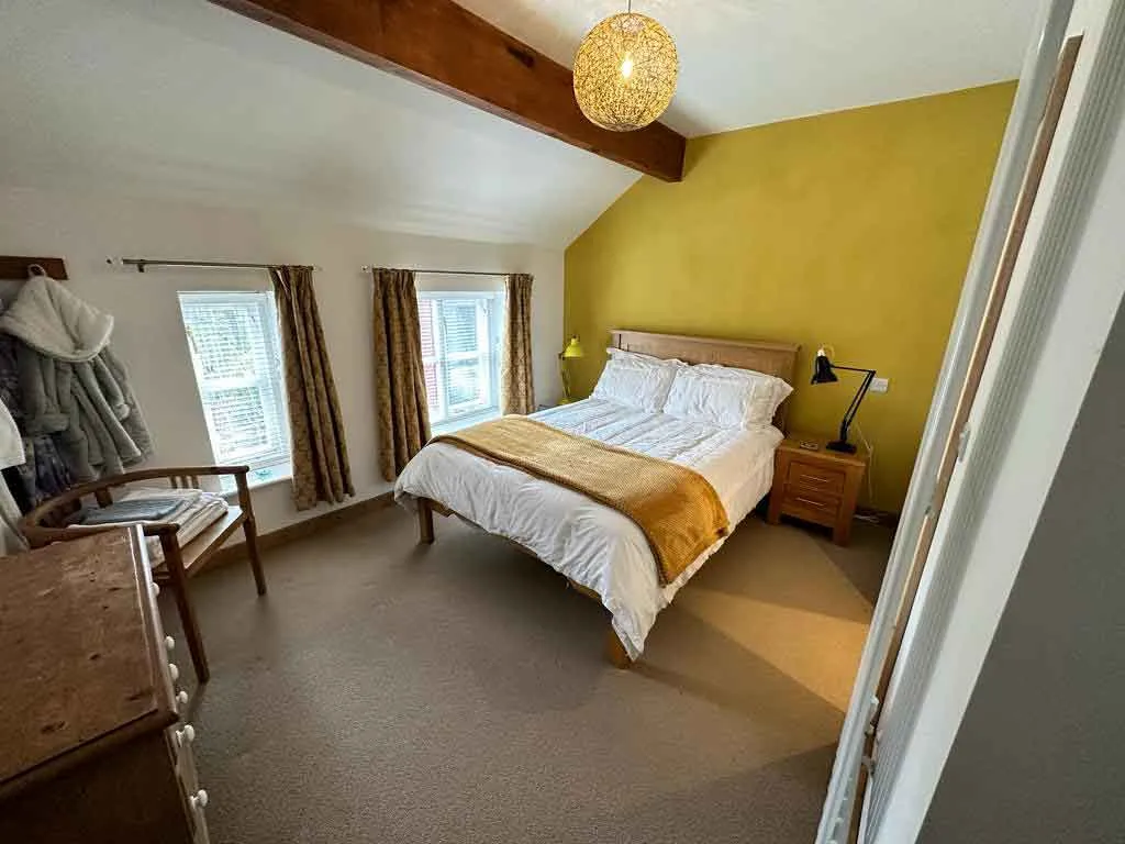 a bedroom with a bed, desk, and chair in it