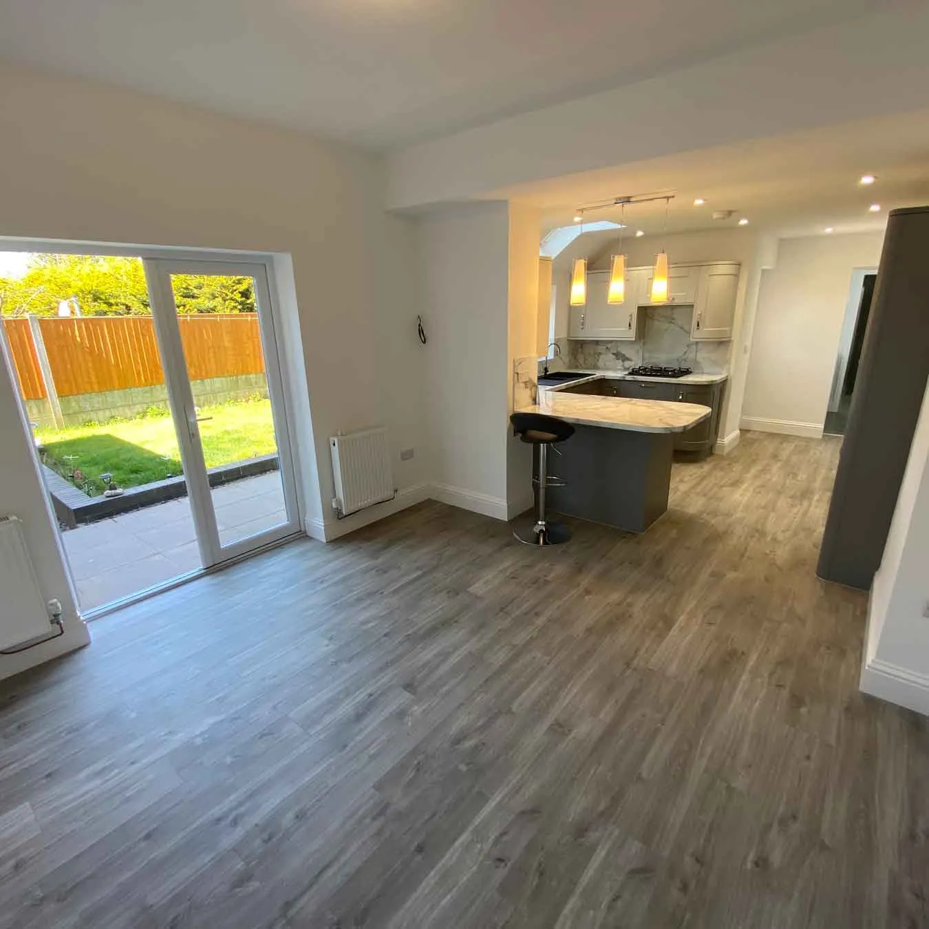 an empty living room with wood floors and sliding glass doors