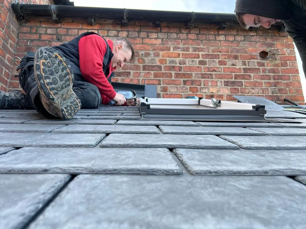a couple of men working on a roof