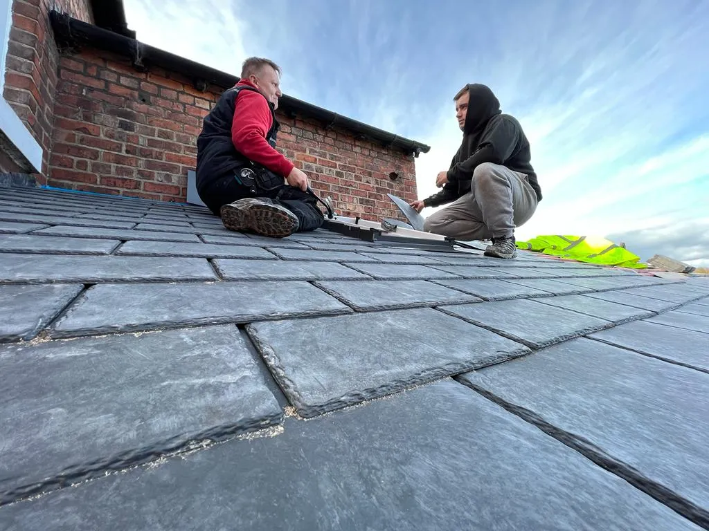 a couple of men sitting on top of a roof