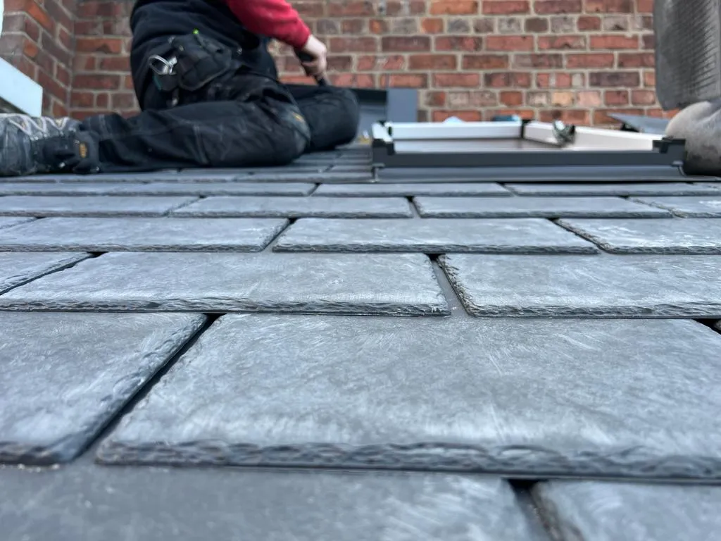 a man laying on the ground working on a roof
