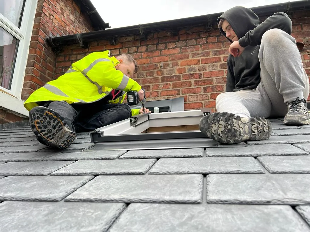 two men working on a slate roof