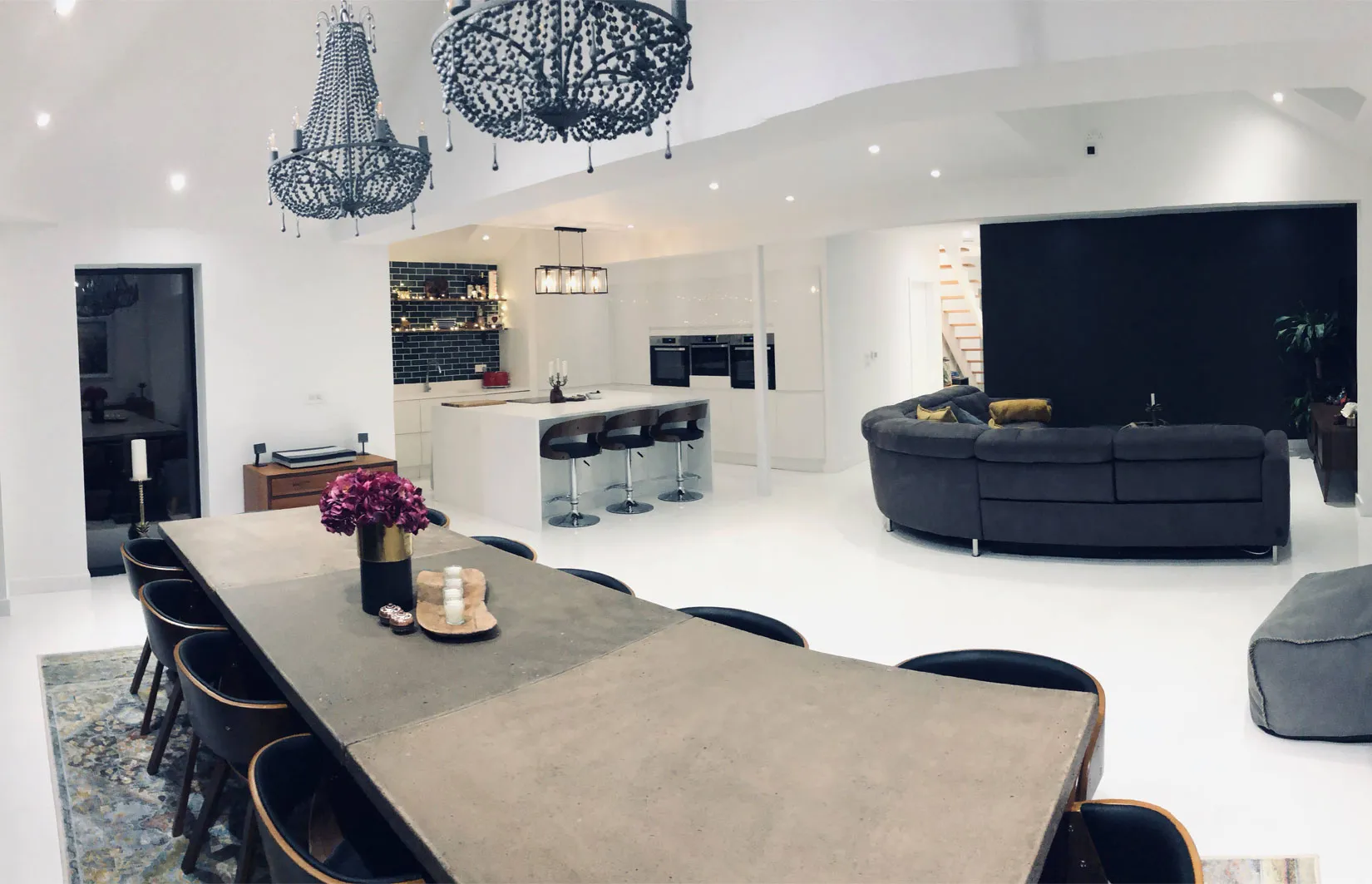 a room with a table, chairs, couches and a chandelier