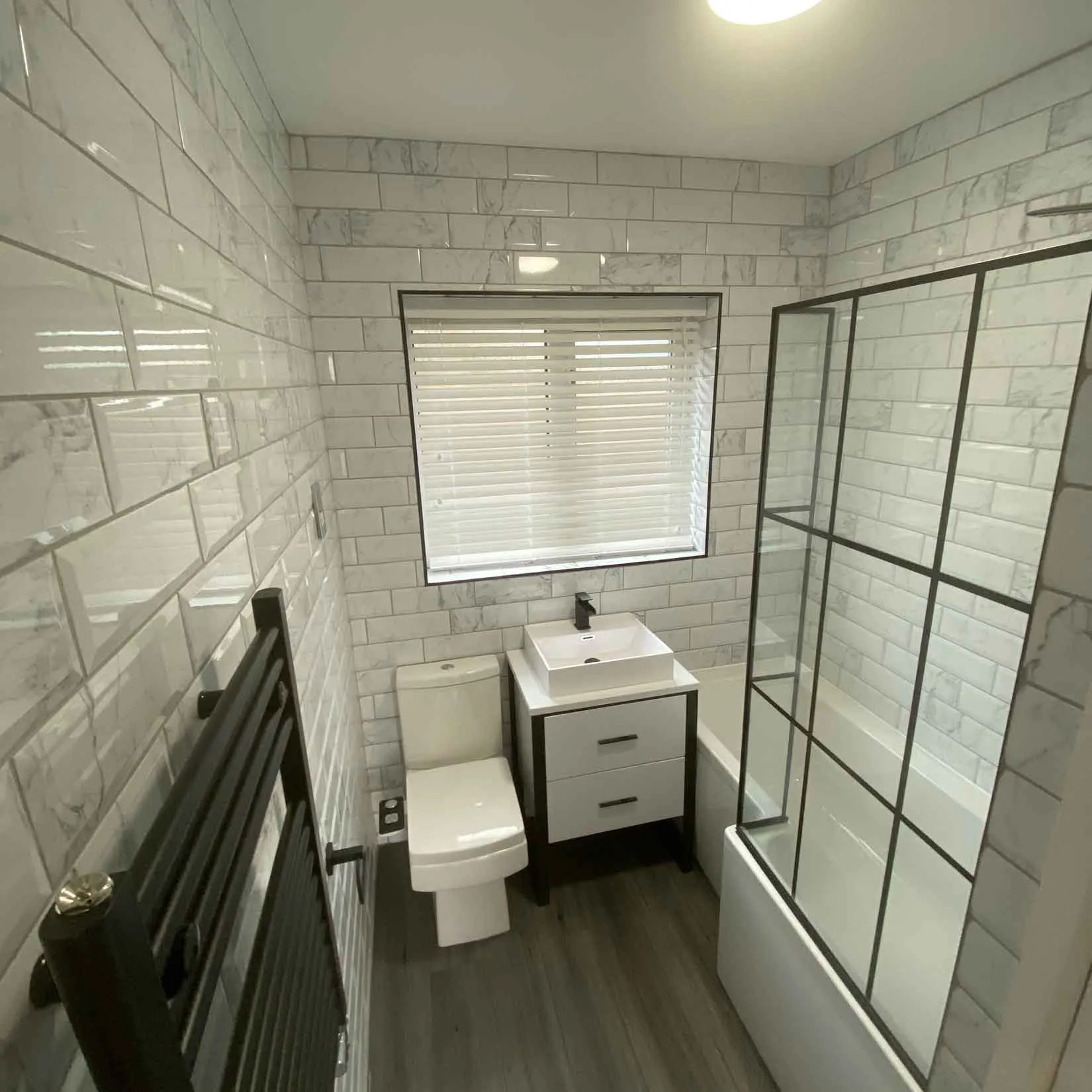 a bathroom with a toilet, sink, and shower