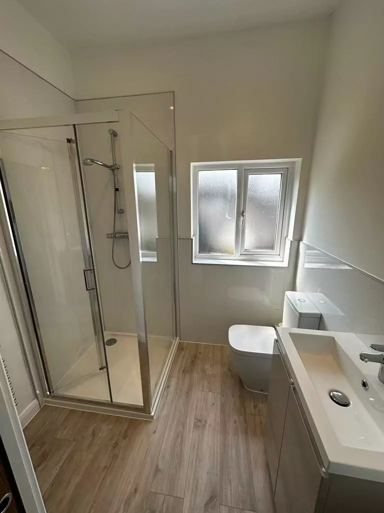 a bathroom with a toilet, sink, and shower