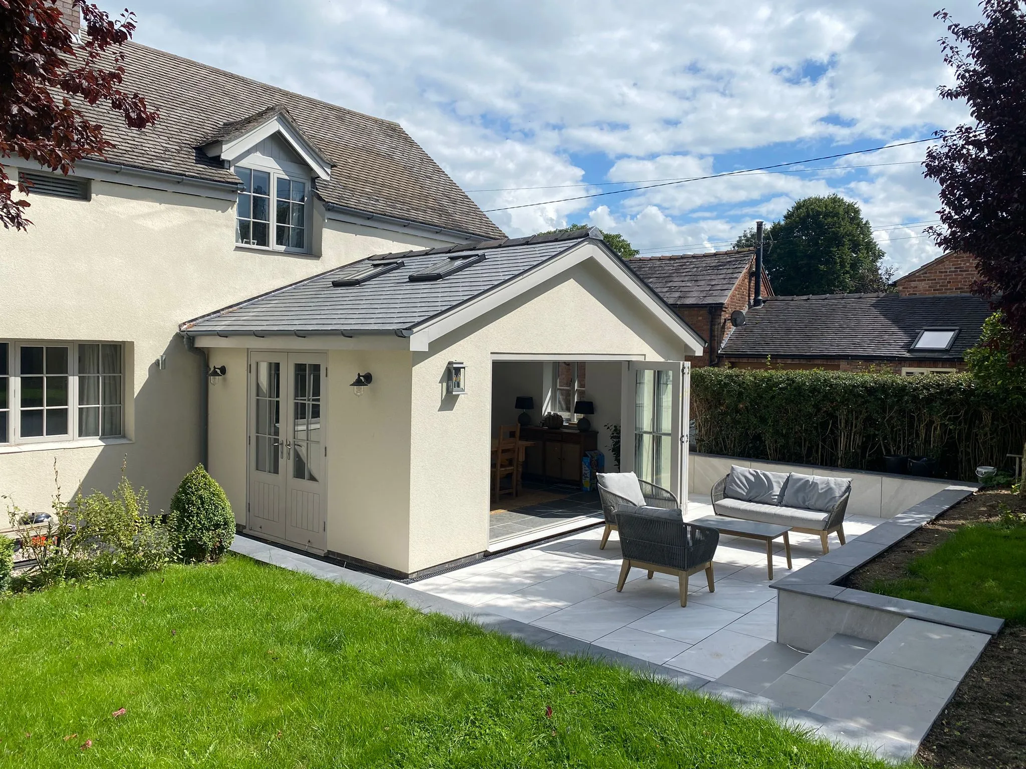 a small white house with a patio and patio furniture