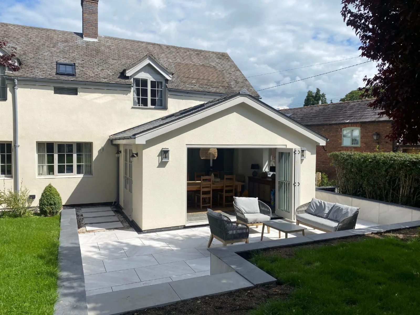 a white house with a patio and chairs