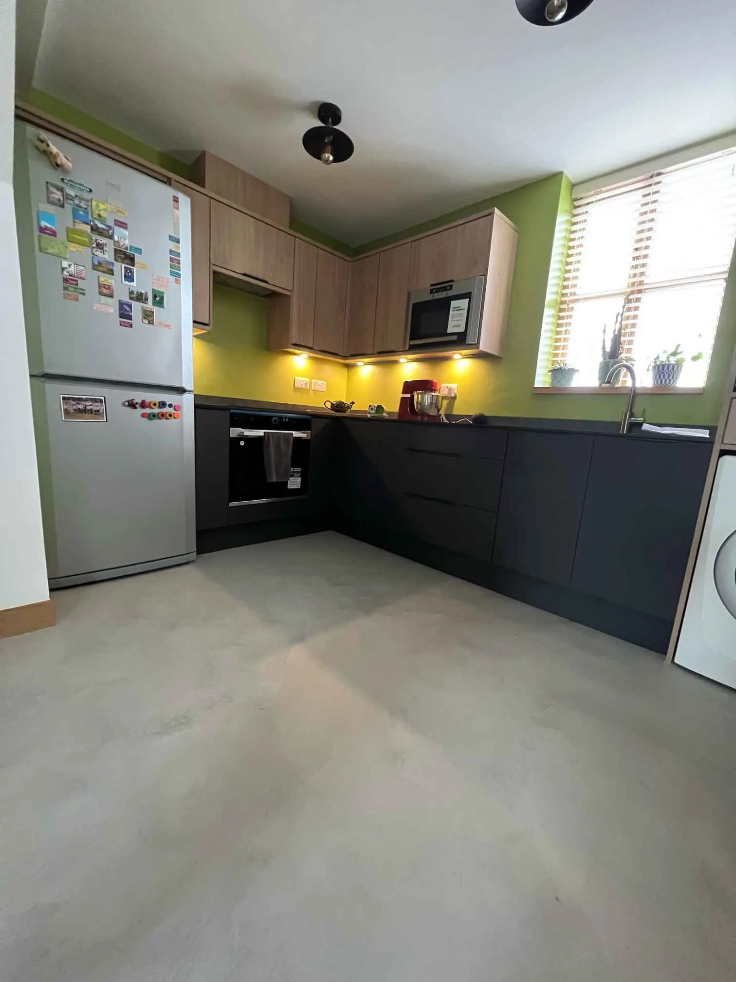 a kitchen with a refrigerator freezer next to a window
