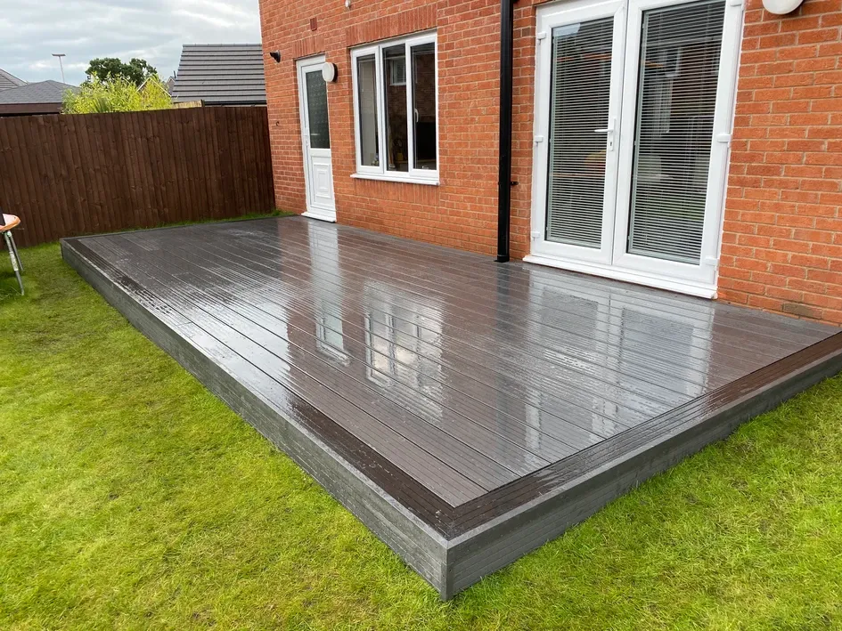 a wooden deck in front of a brick house