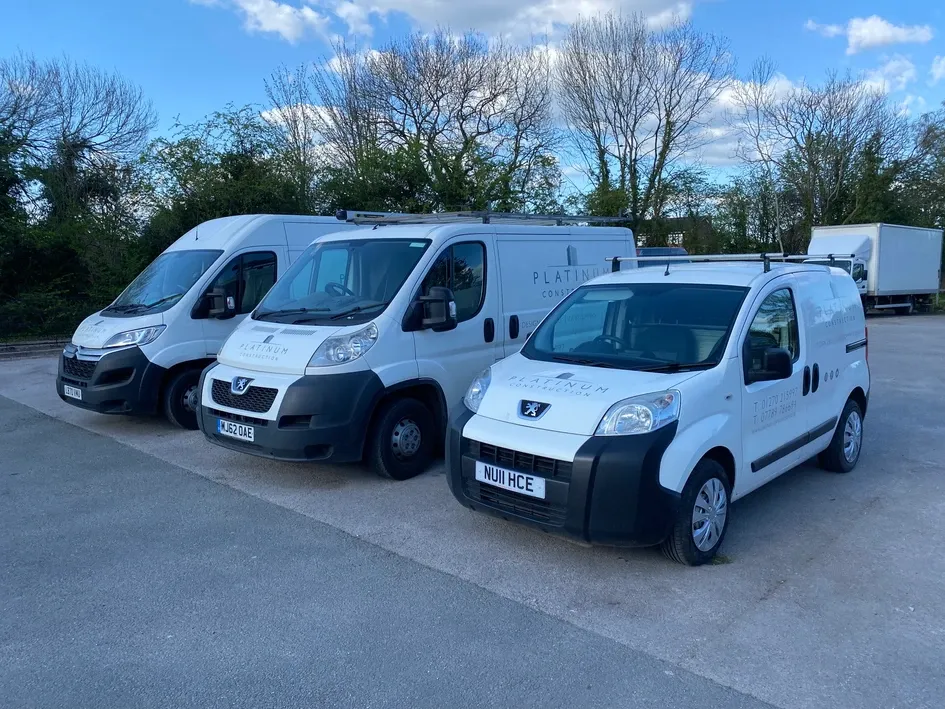 three white vans parked in a parking lot